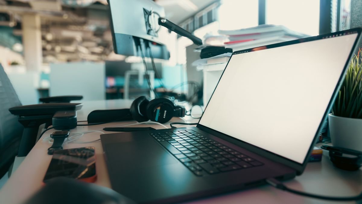 Laptop und Kopfhörer auf einem Schreibtisch