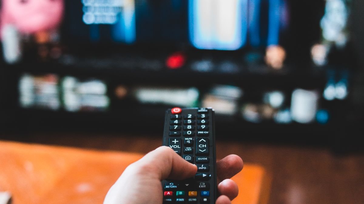 Samsung-Fernbedienung vor einen Fernseher gehalten